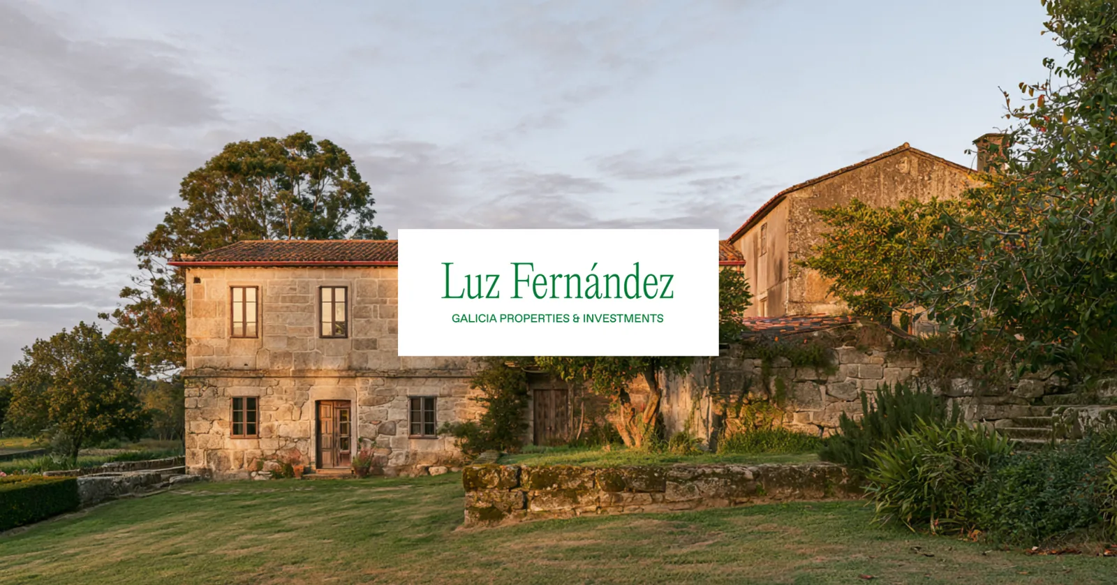 Casa de piedra al atardecer con la marca sobre placa blanca.